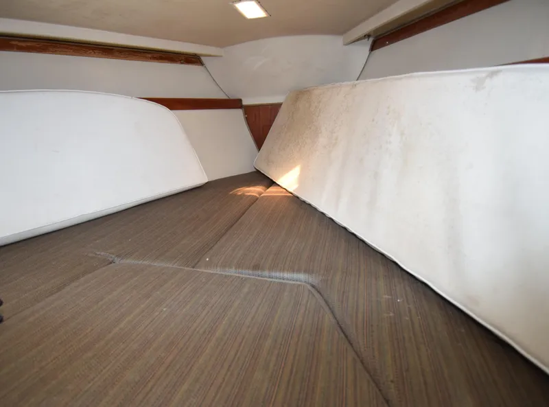 Slide: The Image of Interior cabin of a 1984 Catalina 30 sailboat, featuring cushioned seating and wooden accents. - 6