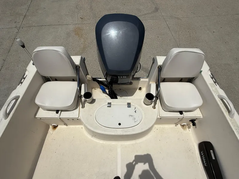 Slide: The Image of 2004 Sea Hunt Escape 175 boat interior with two seats and an outboard motor. - 12