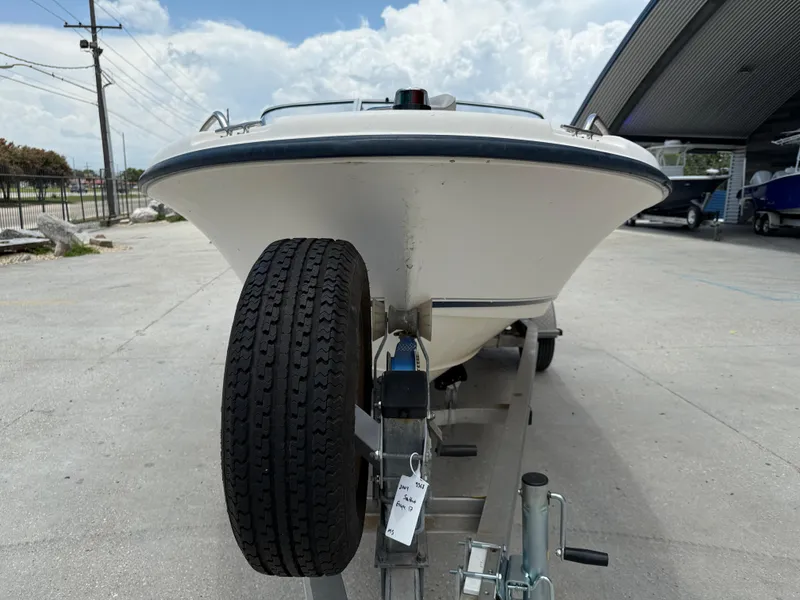 Slide: The Image of 2004 Sea Hunt Escape 175 boat on trailer, parked outdoors under cloudy sky. - 3