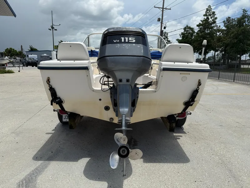 Slide: The Image of 2004 Sea Hunt Escape 175 boat with V4 115 outboard motor, parked outdoors. - 6