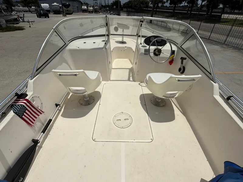 Slide: The Image of 2004 Sea Hunt Escape 175 boat interior with two seats, steering wheel, and American flag. - 8