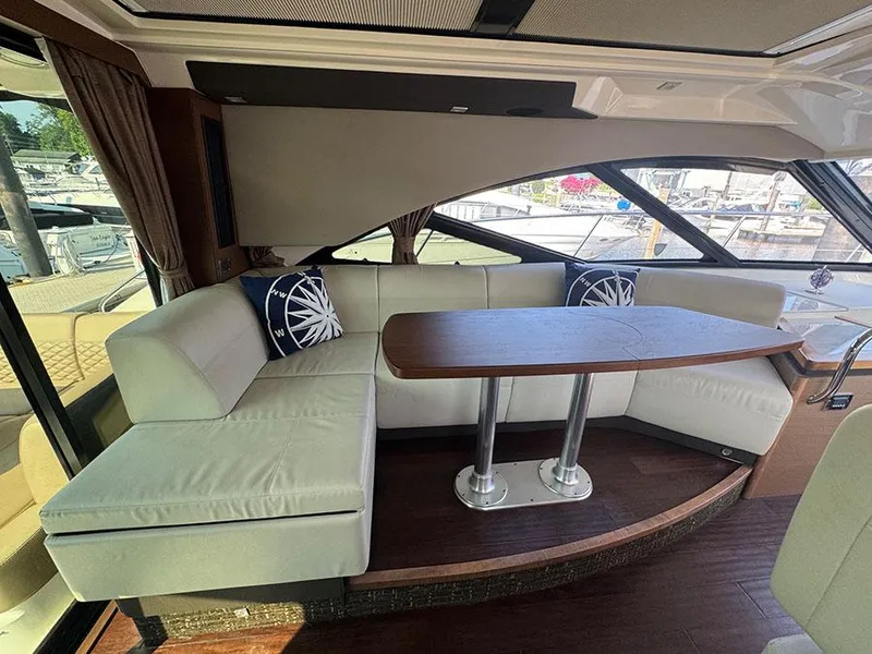 Slide: The Image of Interior of 2015 Sea Ray 510 Sundancer with elegant seating and wooden table. - 10