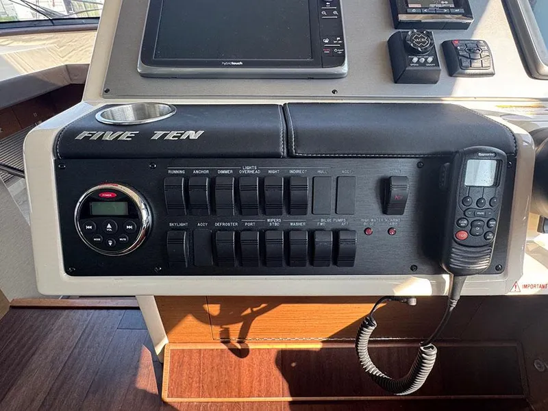 Slide: The Image of Control panel of a 2015 Sea Ray 510 Sundancer yacht with various switches and devices. - 16