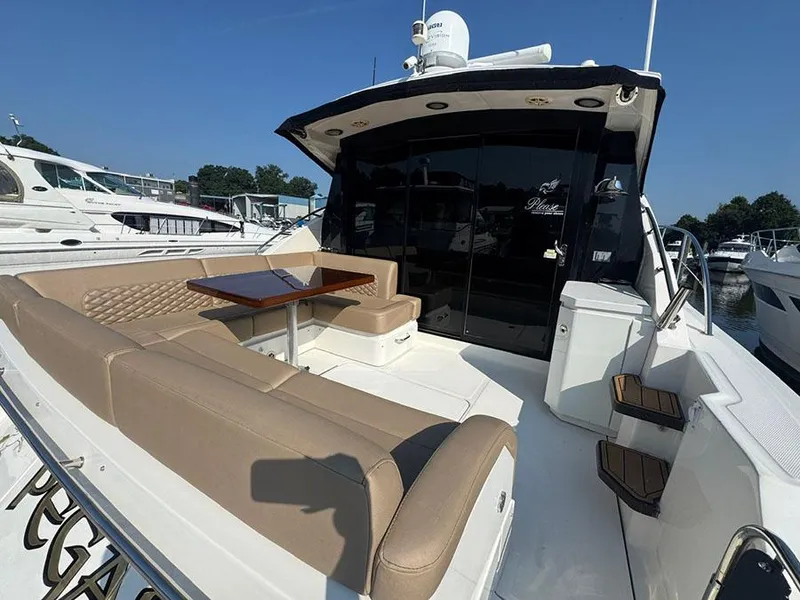 Slide: The Image of 2015 Sea Ray 510 Sundancer yacht with spacious outdoor seating and table. - 4