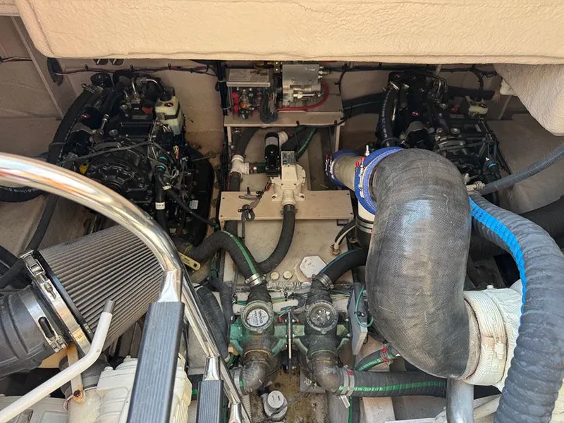Slide: The Image of Engine compartment of a 2015 Sea Ray 510 Sundancer, showcasing mechanical components and hoses. - 46