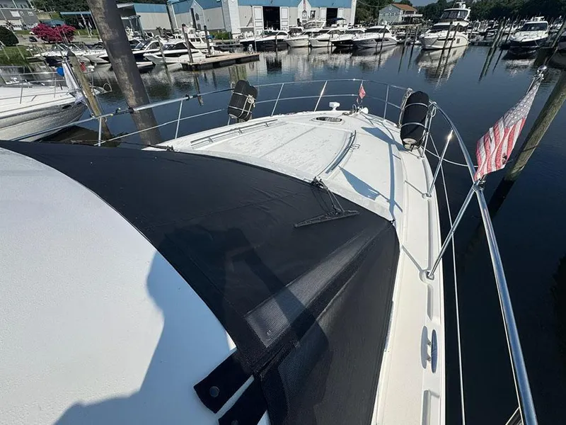 Slide: The Image of 2015 Sea Ray 510 Sundancer yacht docked at marina, featuring sleek design and American flag. - 6