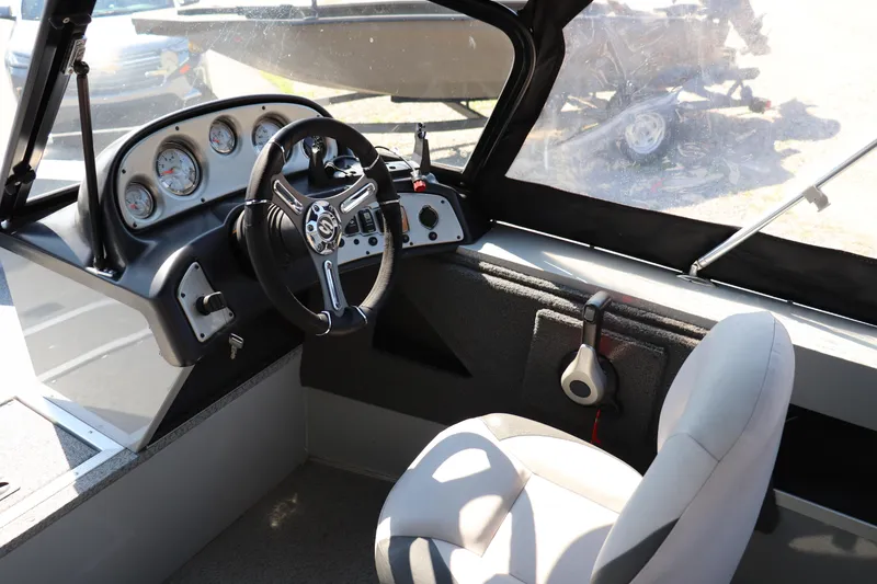 Slide: The Image of Interior of a 2023 Starcraft Osprey 162 boat, featuring steering wheel and dashboard controls. - 5