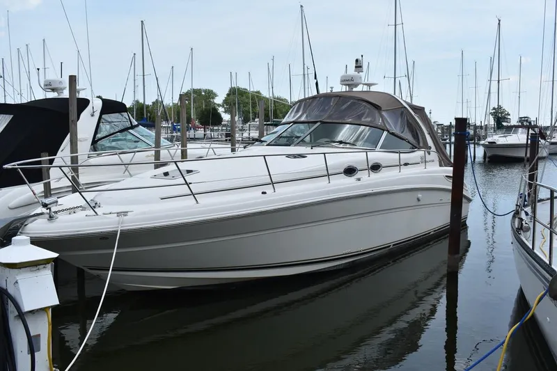 The Image of 2003 Sea Ray 360 Sundancer yacht docked in a marina, surrounded by sailboats. - 0