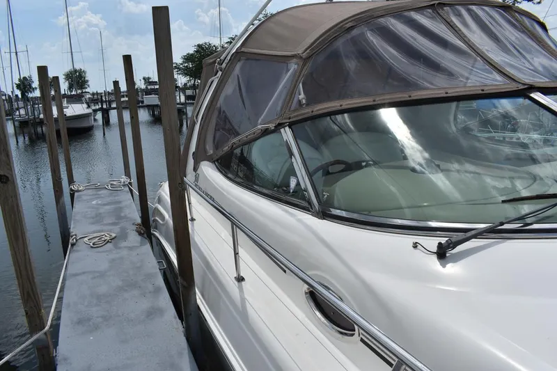Slide: The Image of 2003 Sea Ray 360 Sundancer docked at marina, featuring sleek design and covered cockpit. - 10