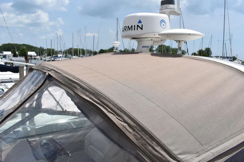 Slide: The Image of 2003 Sea Ray 360 Sundancer with Garmin radar, docked at marina under cloudy sky. - 11