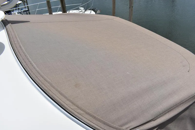 Slide: The Image of 2003 Sea Ray 360 Sundancer boat cover on deck, docked by water. - 12
