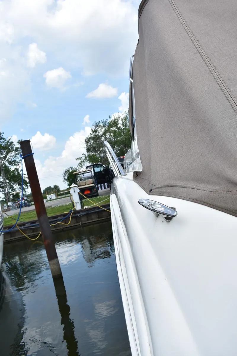 Slide: The Image of 2003 Sea Ray 360 Sundancer docked, featuring sleek design and canvas cover under a cloudy sky. - 16