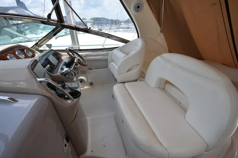 Slide: The Image of 2003 Sea Ray 360 Sundancer cockpit with white seating and steering console. - 22