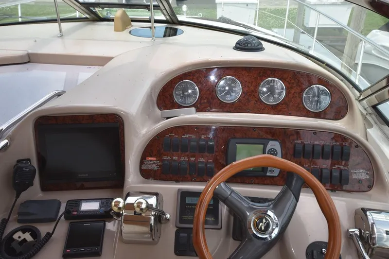 Slide: The Image of Control panel of a 2003 Sea Ray 360 Sundancer boat with gauges and steering wheel. - 24
