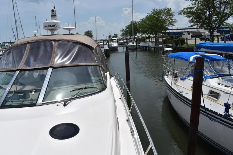 Slide: The Image of 2003 Sea Ray 360 Sundancer docked at marina, clear sky, nearby sailboats. - 9