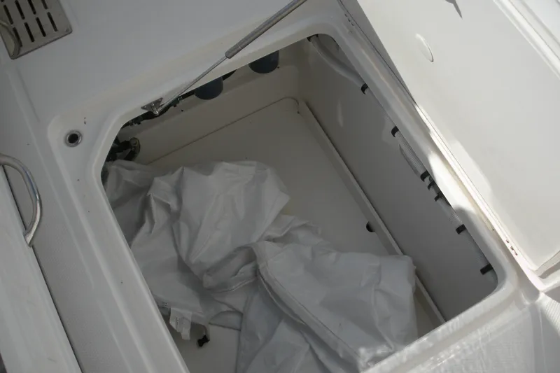 Slide: The Image of Storage compartment of 2026 Robalo R300 Center Console boat with white cover inside. - 17
