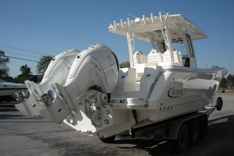 Slide: The Image of 2026 Robalo R300 Center Console boat with dual outboard engines on a trailer. - 22