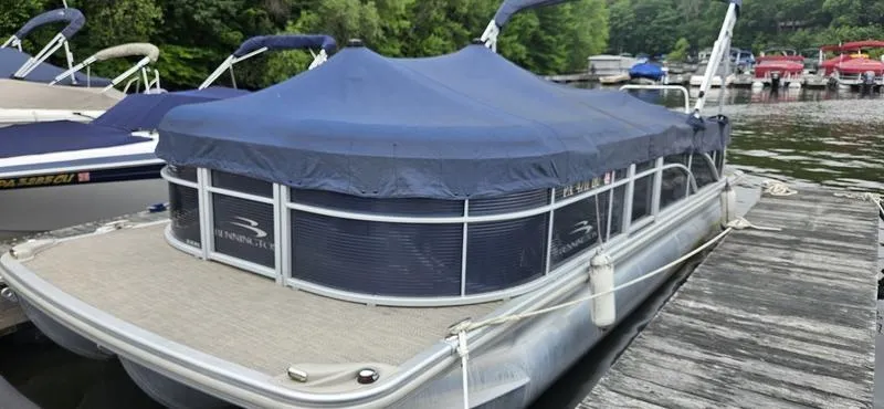 Slide: The Image of 2018 Bennington 22 SCWX pontoon boat docked with blue cover. - 11