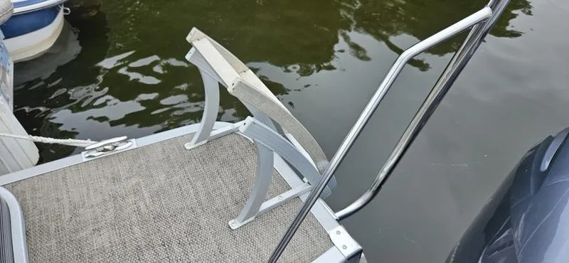 Slide: The Image of 2018 Bennington 22 SCWX boat ladder and deck by the water. - 8