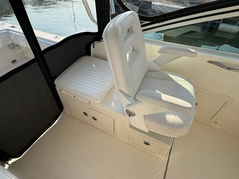 Slide: The Image of White captain's chair on 2014 Carolina Classic 25 boat, near water. - 10