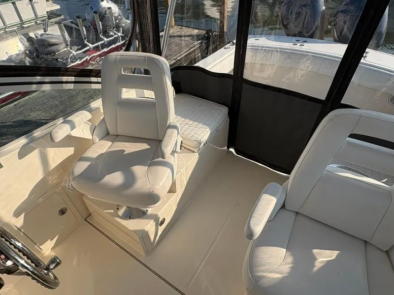 Slide: The Image of Interior of 2014 Carolina Classic 25 boat with white seating and steering wheel. - 11