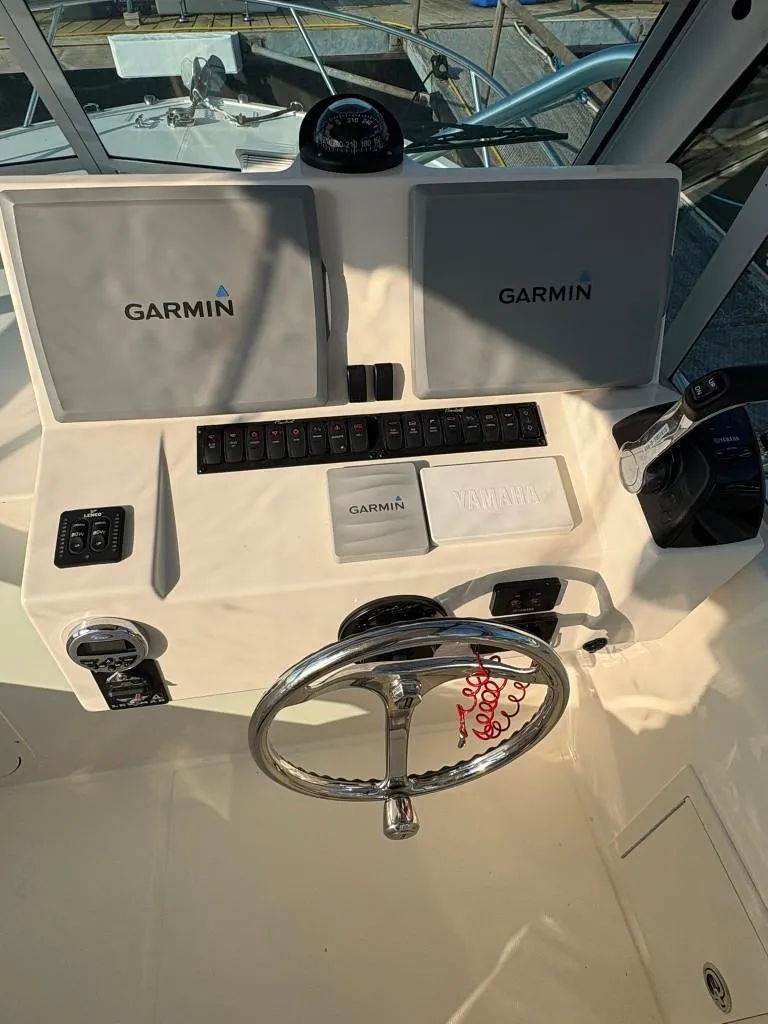 Slide: The Image of Helm of 2014 Carolina Classic 25 with Garmin navigation displays and steering wheel. - 12