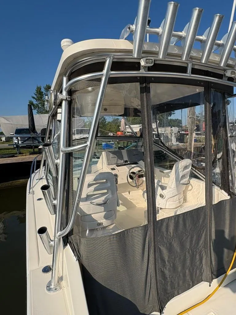 Slide: The Image of 2014 Carolina Classic 25 boat with enclosed cockpit and fishing rod holders. - 18