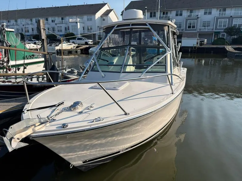 Slide: The Image of 2014 Carolina Classic 25 boat docked in marina, surrounded by residential buildings. - 3