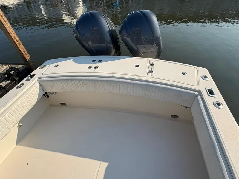 Slide: The Image of 2014 Carolina Classic 25 boat with dual engines, docked on calm water. - 4