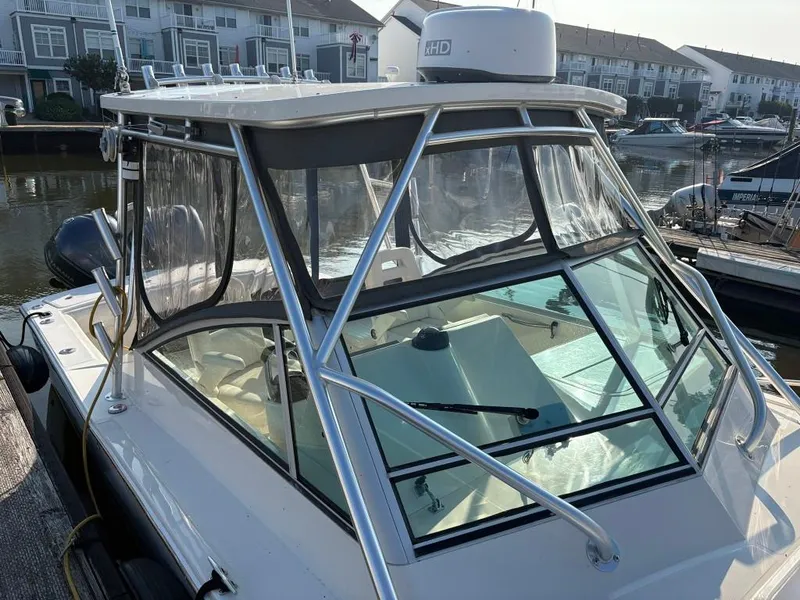 Slide: The Image of 2014 Carolina Classic 25 boat docked, featuring a clear enclosure and radar equipment. - 6