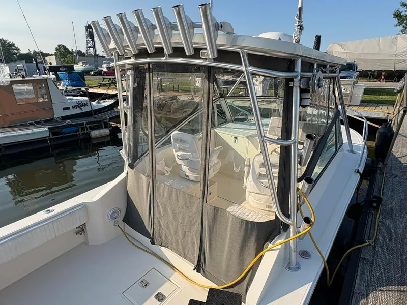 Slide: The Image of 2014 Carolina Classic 25 boat docked, featuring a covered cockpit and fishing rod holders. - 7