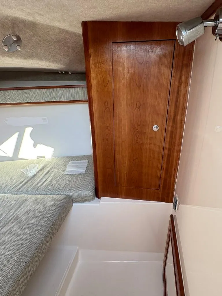 Slide: The Image of 2014 Carolina Classic 25 cabin interior with wooden door and bed. - 9