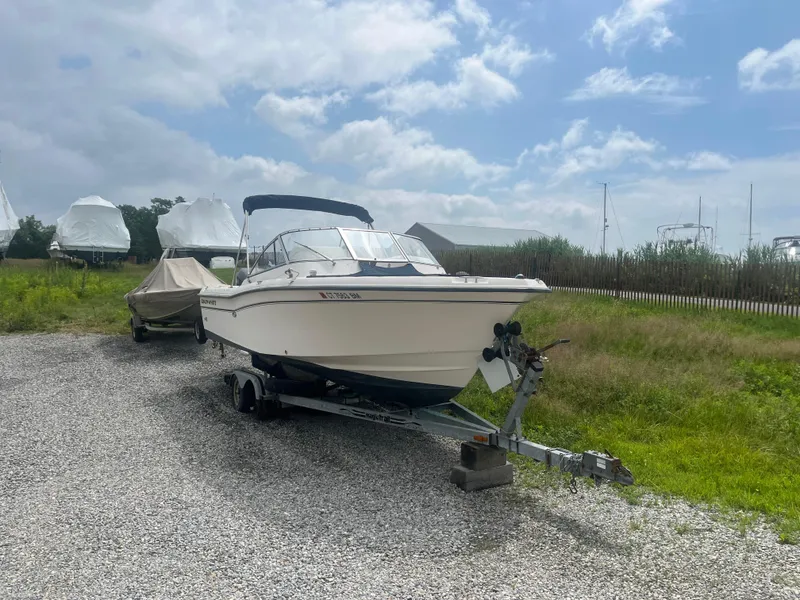 The Image of 2006 Grady-White Tournament 225 boat on trailer, parked outdoors under cloudy sky. - 0