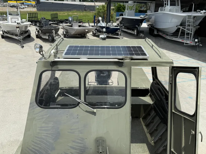 Slide: The Image of Custom Aluminum 2073 Cabin boat with solar panel, parked among other boats. - 13