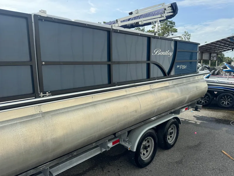 Slide: The Image of 2021 Bentley Pontoons 243 FISH 4PT on trailer, side view, outdoor setting. - 4