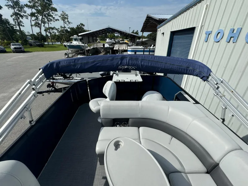 Slide: The Image of 2021 Bentley Pontoons 243 FISH 4PT with seating and canopy, parked near a building. - 9