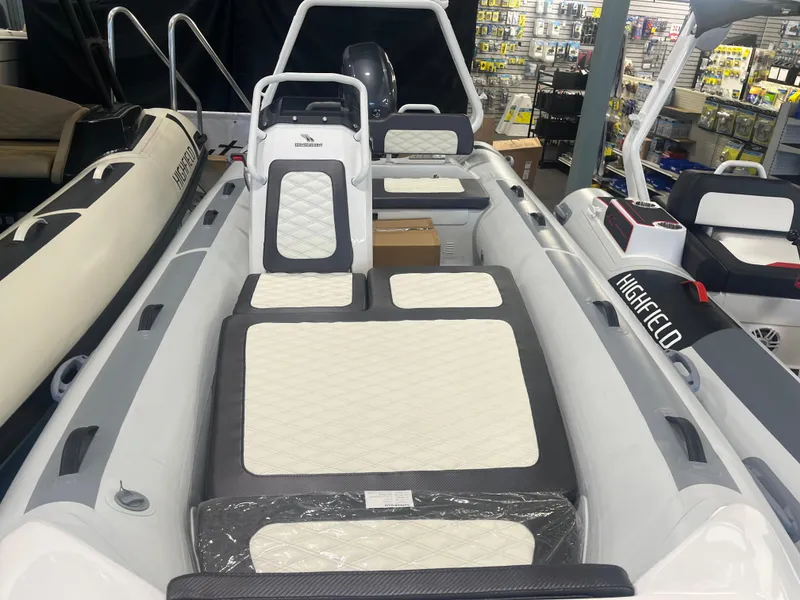 Slide: The Image of 2026 Highfield Velox 420 boat interior with cushioned seating, displayed in a showroom. - 16