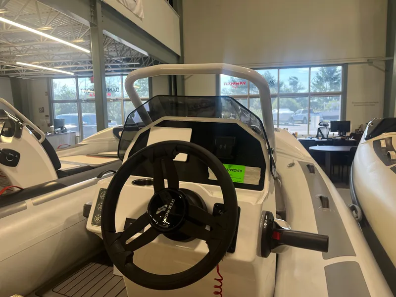 Slide: The Image of 2026 Highfield Velox 420 boat interior with steering wheel in showroom setting. - 18
