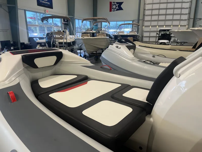Slide: The Image of 2026 Highfield Velox 420 inflatable boat interior in showroom, featuring cushioned seating. - 4