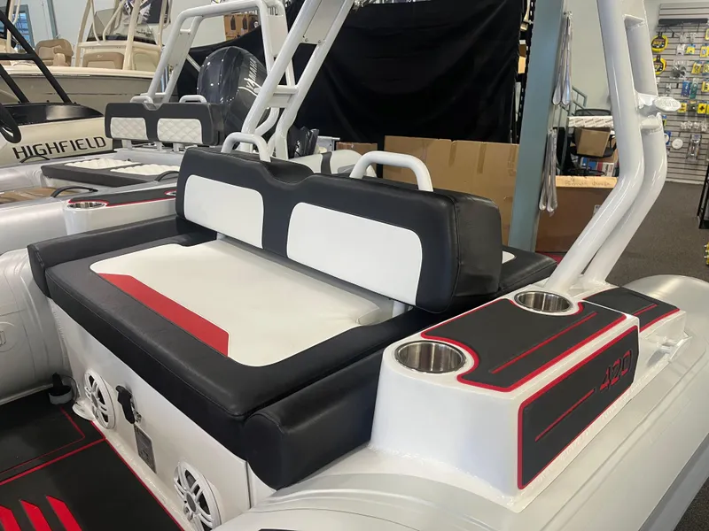 Slide: The Image of Highfield Velox 420 boat interior, 2026 model, featuring black and white seating with cup holders. - 5