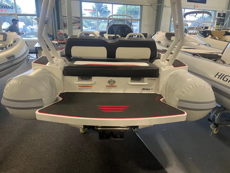 Slide: The Image of 2026 Highfield Velox 420 boat interior, featuring seating and Rotax engine, displayed indoors. - 7