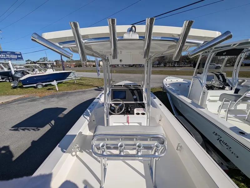 Slide: The Image of 2025 Bay Rider 239 Bay boat with center console and rod holders, parked outdoors. - 8