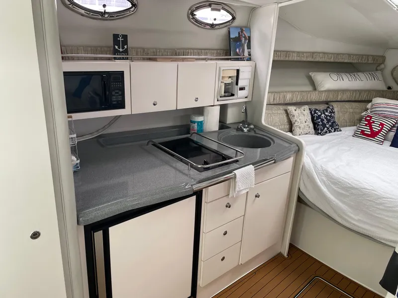 Slide: The Image of 2002 Wellcraft 330 Coastal interior with kitchenette, sink, and cozy sleeping area. - 12