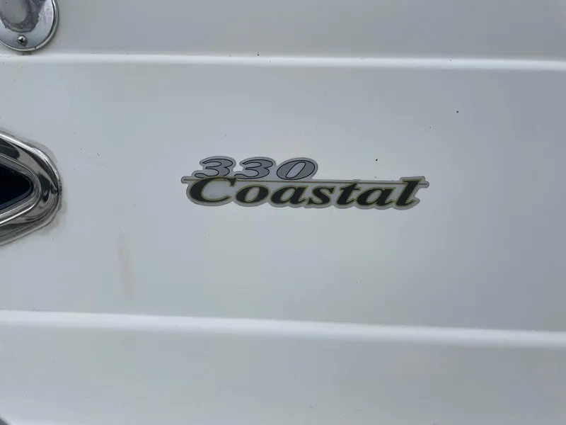 Slide: The Image of Wellcraft 330 Coastal 2002 model logo on white boat exterior. - 16