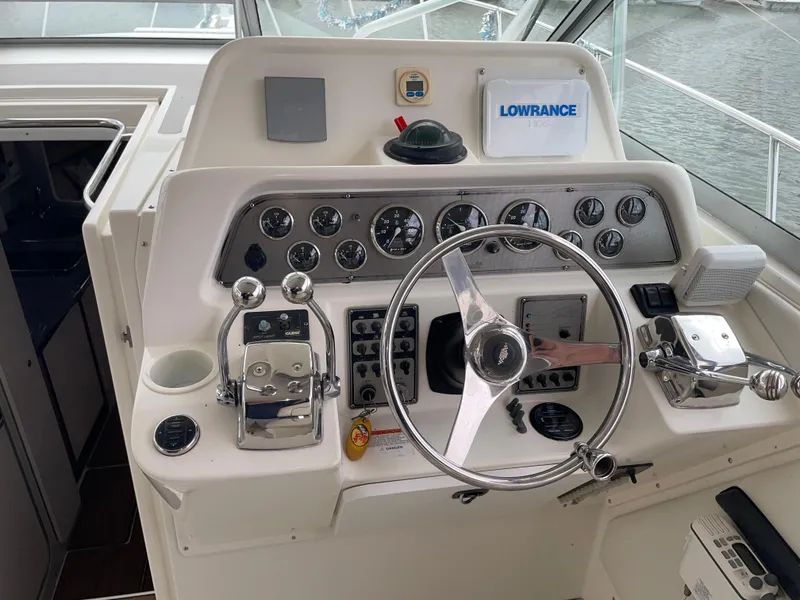 Slide: The Image of Control panel of a 2002 Wellcraft 330 Coastal boat with steering wheel and navigation instruments. - 17