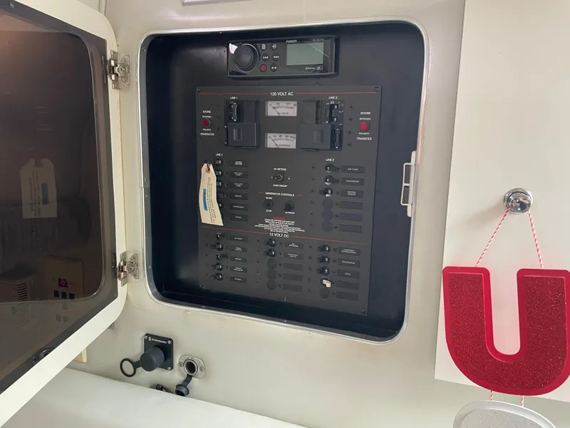 Slide: The Image of Electrical panel inside a 2002 Wellcraft 330 Coastal boat, featuring various switches and controls. - 27