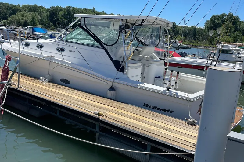 Slide: The Image of 2002 Wellcraft 330 Coastal boat docked at marina, surrounded by other vessels. - 5
