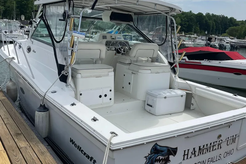 Slide: The Image of 2002 Wellcraft 330 Coastal boat docked, featuring spacious seating and fishing equipment. - 6