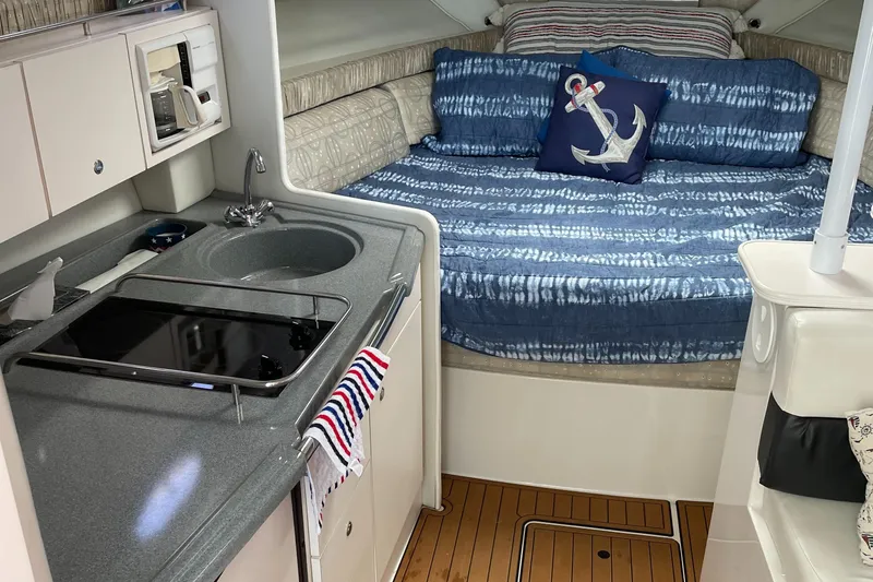 Slide: The Image of Interior of 2002 Wellcraft 330 Coastal boat with cozy bed and compact kitchen area. - 9