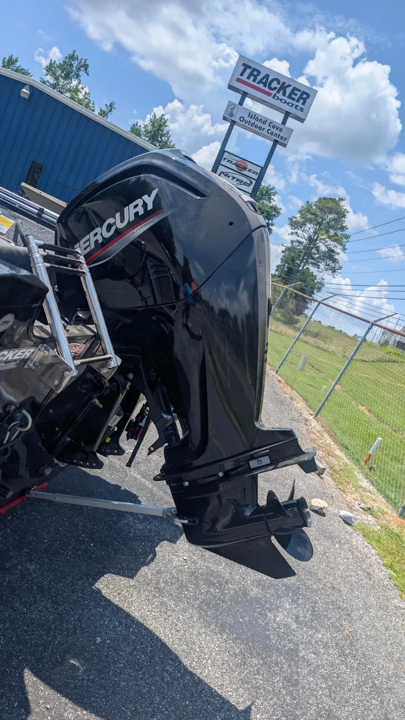 Slide: The Image of 2022 Tracker Pro Guide V 16 SC boat with Mercury outboard motor, outdoor center sign in background. - 3